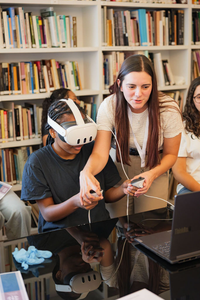 Aluna experimenta óculos de realidade virtual com a ajuda de uma investigadora.