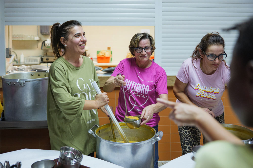 Voluntárias servem sopa durante o reforço alimentar.
