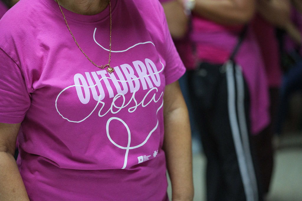 Pormenor da t-shirt cor-de-rosa da campanha Outubro Rosa.
